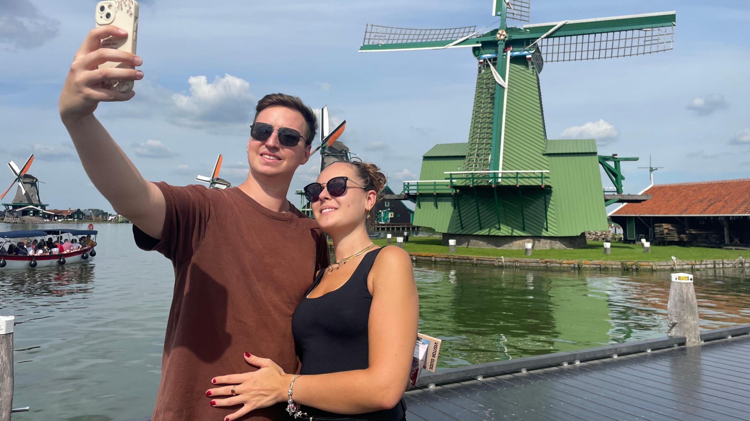 A couple taking a selfie in front of the windmills