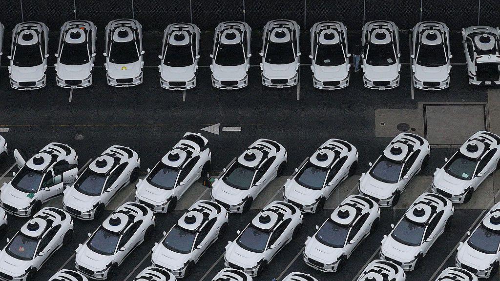 An overhead view of a fleet of white Waymo vehicles 